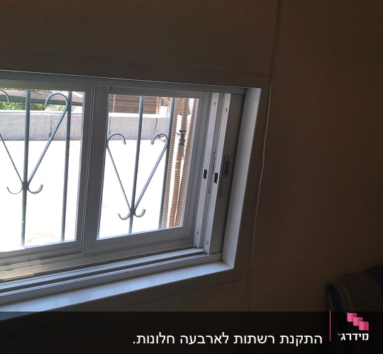 חלון אלומיניום עם מסגרת לבנה וסורגים